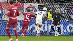 Pemain Inggris, Jude Bellingham, mencetak gol melalui tandukan kepala saat melawan Serbia pada laga Grup C Euro 2024 di Veltins Arena hari Senin (17/06/2024). (AP Photo/Thanassis Stavrakis)