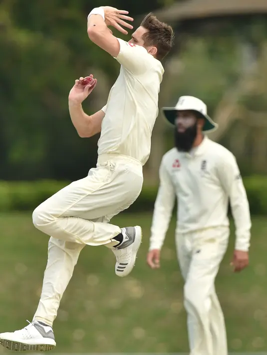 Pemain Inggris Chris Woakes bersiap melempar bola saat bertanding melawan Cricket Australia XI pada hari ketiga pertandingan tur empat hari Ashes di Stadion Tony Ireland di Townsville (17/11). (AFP Photo/Peter Parks)