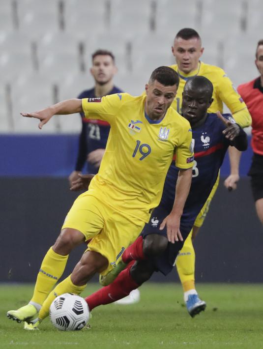 Penyerang Ukraina, Junior Moraes membawa bola dari kejaran gelandang Prancis, Ngolo Kante pada pertandingan kualifikasi Piala Dunia D di stadion Start de France, di Saint Denis, utara Paris, Kamis (25/3/2021). Prancis bermain imbang atas Ukraina 1-1. (AP Photo/Thibault Camus)