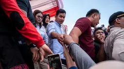 Beberapa diantaranya berebut untuk bisa bersalaman dan berswafoto bersama Calon Wakil Presiden, Gibran Rakabuming Raka. (Juni Kriswanto/AFP)