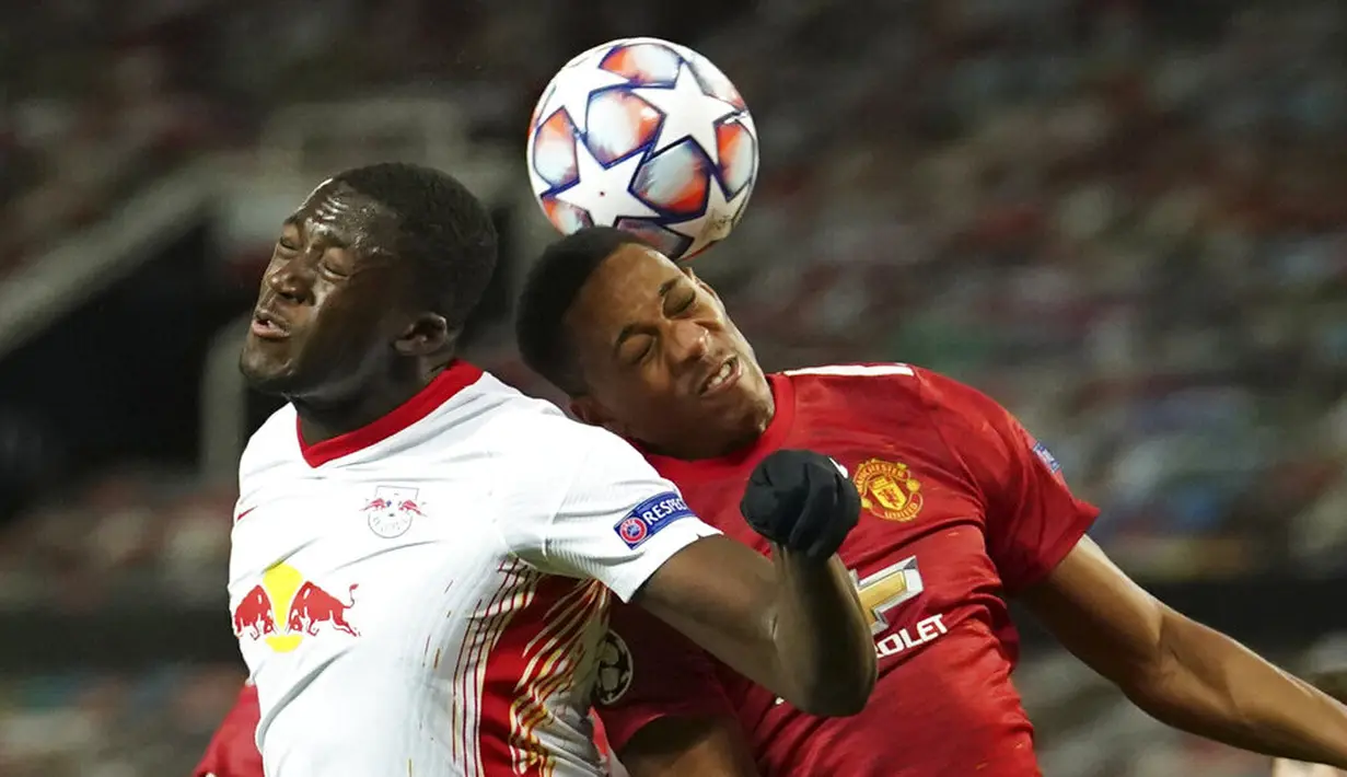 Penyerang Manchester United, Anthony Martial, duel udara dengan pemain RB Leipzig, Ibrahima Konate, pada laga Liga Champions di Stadion Old Trafford, Kamis (29/10/2020). MU menang dengan skor 5-0. (AP/Dave Thompson)