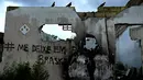 Grafiti tertulis di dinding rumah yang ditinggalkan di lingkungan Farol maceio, negara bagian Alagoas, Brasil, 6 Maret 2022. Farol adalah salah satu lingkungan yang telah ditinggalkan karena ancaman penurunan tanah yang disebabkan oleh tambang Braskem. (AP Photo/Eraldo Peres)