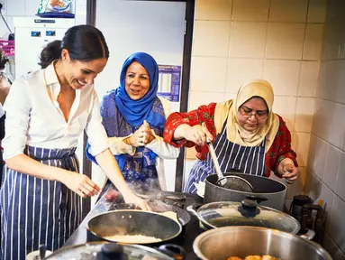 Duchess of Sussex, Meghan Markle saat memasak bersama kelompok Hubb Community Kitchen yang mayoritas beragama Islam saat  melakukan proyek amal di Al Manaar Muslim Cultural Heritage Centre, London, Inggris (19/7). (Jenny Zarins/Kensington Palace via AP)