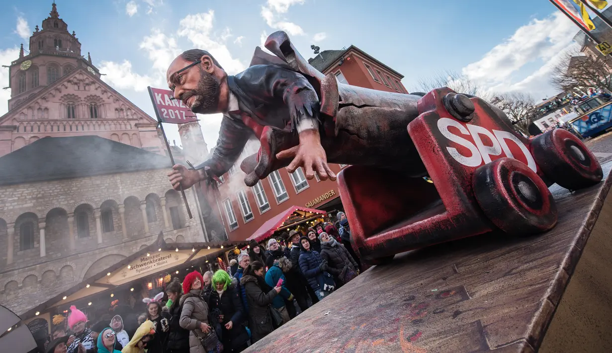 Kereta karnaval membawa karikatur  penantang Angela Merkel pada pemilihan tahun lalu, Martin Schulz saat parade karnaval Rose Monday di Duesseldorf, Jerman, Senin (12/2). Rose Monday tahun ini mengambil tema parodi tokoh politik (Andreas Arnold/dpa/AFP)