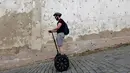 Seorang turis menggunakan segway di jalanan menurun di pusat kota Praha, Ceko, Selasa (19/7). Segway yang merupakan kendaraan personal listrik beroda 2 yang mampu menyeimbangkan sendiri itu kini menjadi favorit para turis. (REUTERS/David W Cerny)