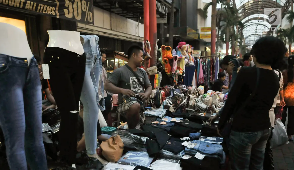 Pedagang melayani calon pembeli di kawasan perbelanjaan Pasar Baru, Jakarta Pusat, Rabu (21/6). Menjelang lebaran, kawasan perbelanjaan Pasar Baru mulai diserbu warga untuk berbelanja kebutuhan lebaran. (Liputan6.com/Yoppy Renato)