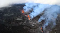 Foto udara pada 22 Desember 2021 menunjukkan gunung berapi Piton de la Fournaise yang meletus di pulau Reunion, Samudra Hindia Prancis. Gunung yang memiliki ketinggian 2632 meter ini meletus untuk kedua kalinya dalam setahun pada 22 Desember pukul 3:30 (12:30 di Paris).  (Richard BOUHET/AFP)