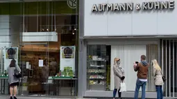 Sejumlah orang berdiri di luar toko yang dibuka kembali di jalan Graben di Wina, Austria, (14/4/2020). Austria menjadi salah satu negara pertama di Eropa yang melonggarkan kebijakan karantina nasional atau “lockdown” pandemi virus corona. (Xinhua/Guo Chen)