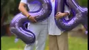Pasangan yang telah dikaruniai dua orang anak itu memegang balon dengan angka 24. Sebagai hari anniversary pernikahannya. [Instagram/bu_deedee]