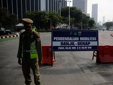 Petugas gabungan melakukan penyekatan di pos penyekatan ganjil-genap di Bundaran Senayan, Minggu (5/9/2021). Pembatasan kendaraan dengan sistem pelat nomor kendaraan ini tetap berlaku di akhir pekan, Sabtu dan Minggu. (Liputan6.com/Angga Yuniar)