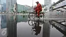 Seorang warga bersepeda di kawasan Car Free Day, Jakarta, Minggu (28/2/2016). Hujan yang mengguyur Ibukota sejak semalam hingga pagi membuat kawasan CFD sepi pengunjung. (Liputan6.com/Immanuel Antonius)