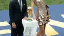 Mantan kapten Jerman Philipp Lahm (kiri) dan model Rusia Natalia Vodianova (kanan) mempersembahkan trofi Piala Dunia pada penutupan Piala Dunia 2018 Rusia di Stadion Luzhniki, Moskow (15/7). (AFP Photo / Adrian Dennis)
