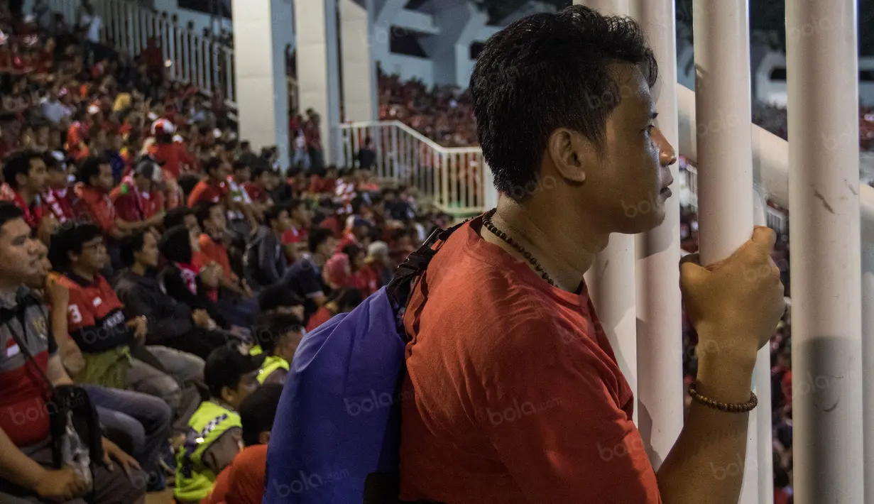 Seorang suporter tampak serius saat menonton laga semifinal Piala AFF 2016 melawan Vietnam di Stadion Pakansari, Jawa Barat, Sabtu (3/12/2016). (Bola.com/Vitalis Yogi Trisna)