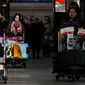 Penumpang mendorong troli barang bawaan saat tiba di Bandara Internasional Beijing pada Senin (20/1/2020). China berada di tengah-tengah kesibukan migrasi manusia tahunan ketika jutaan orang pulang ke kampung halaman mereka untuk menikmati libur Tahun Baru Imlek bersama keluarga. (WANG Zhao/AFP)