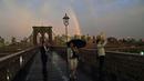 Warga mengabadikan keindahan pelangi dari Jembatan Brooklyn di New York City, AS (15/5). Jembatan Brooklyn adalah salah satu jembatan suspensi tertua di Amerika Serikat. (AFP Photo/Hector Retamal)