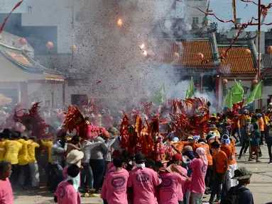 Sejumlah warga menyalakan petasan saat merayakan festival keagamaan tahunan untuk Dewi yang sangat dihormati dari Kuil Chao Mae To Mo di distrik Sungai Kolok, Thailand (8/5). (AFP/Madaree Tohlala)