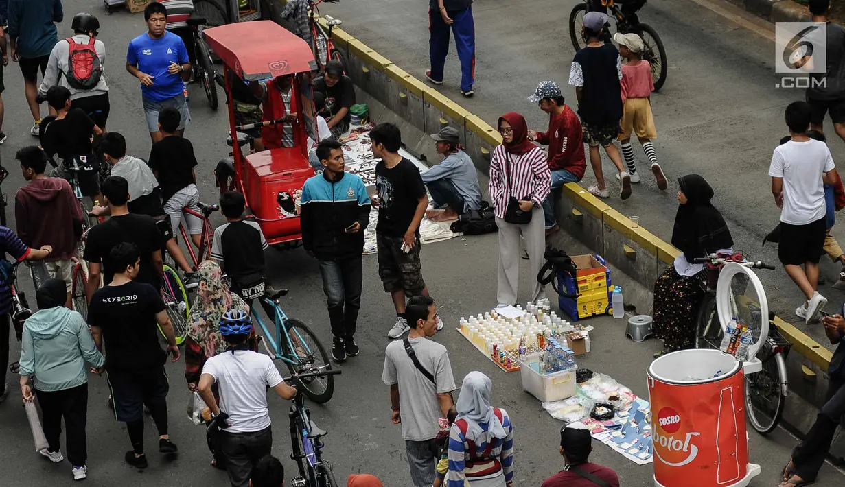 Pedagang Kaki Lima (PKL) berjualan selama kegiatan Car Free Day (CFD) di sepanjang Jalan Sudirman, Jakarta, Minggu (9/12). Kurangnya pengawasan menyebabkan banyak PKL yang berjualan tidak pada tempatnya dan memenuhi area CFD. (Liputan6.com/Faizal Fanani)