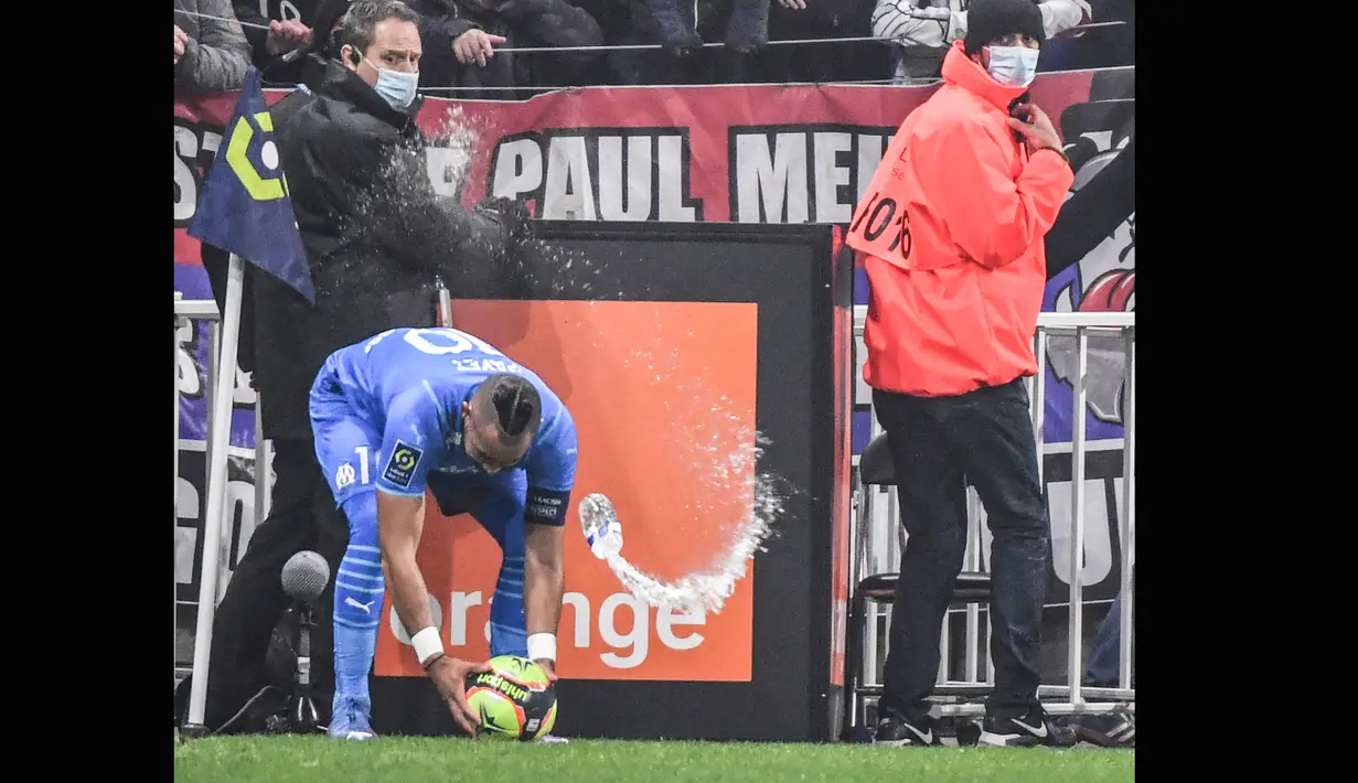 Pada saat itu pemain Marseille Dimitri Payet berada di sudut lapangan untuk bersiap mengambil tendangan penjuru. Tiba-tiba ada sebuah botol minuman melayang dari arah tribune penonton dan telak mengenai Payet. (AFP/Philippe Desmazes)
