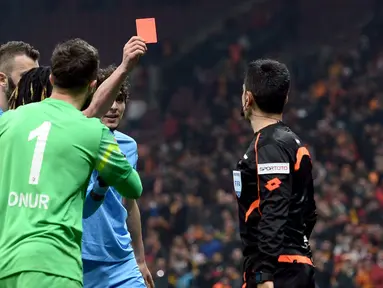 Pemain Trabzonspor, Salih Dursun, memberi kartu merah kepada wasit Deniz Bitnel (kanan) saat laga Liga Super Turki melawan Galatasaray di Istanbul, Turki, (21/2/2016). Salih Dursun sebelumnya mendapat kartu merah dari wasit. (Reuters/Str)