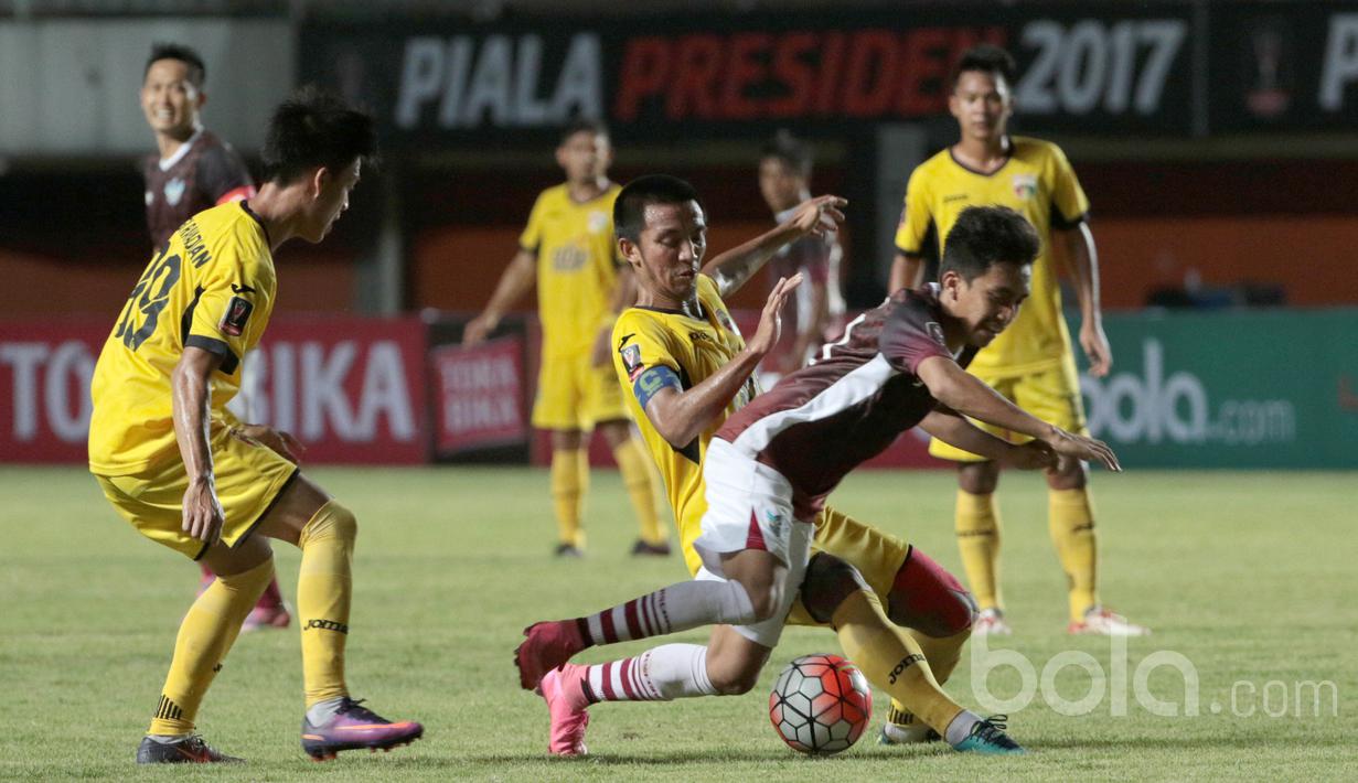 Bayu Pradana (tengah) menghadang laju pemain Gresik United pada partai kedua Grup 1 Piala Presiden 2017 di Stadion Maguwoharjo, Sleman, Sabtu (4/2/2017). Mitra Kukar menang 1-0. (Bola.com/Nicklas Hanoatubun)