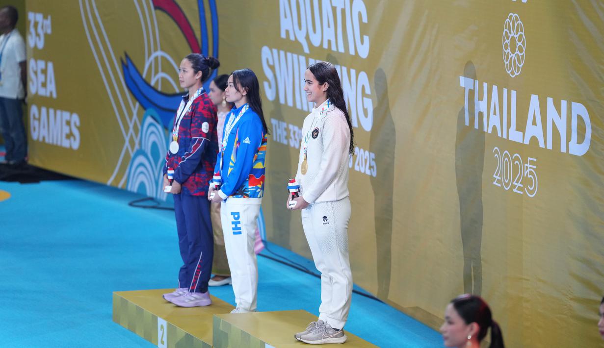 Perenang putri Indonesia, Masniari Wolf, saat dikalungkan medali emas SEA Games 2025 setelah menjadi yang tercepat di cabang olahraga renang nomor 50 meter gaya punggung putri di Swimming Pool, Sports Authority of Thailand, Bangkok, Kamis (11/12/2025) sore WIB. (Dok. Akuatik Indonesia)