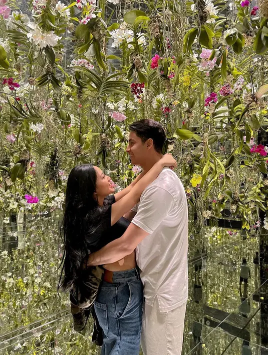 Lucunya pose berpelukan ala Rachel dan Salim. Keduanya berada di dalam sebuah ekshibisi, Rachel tampak mengenakan cropped top hitam dipadu celana jeans, sedangkan Salim mengenakan all white outfit; kaus dan celana panjang. Foto: Instagram.