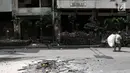 Seorang pemulung melintasi sisa kericuhan di sekitar Pasar Tanah Abang, Jakarta, Rabu (22/5/2019). Tak ada aktivitas perdagangan pagi ini di Pasar Tanah Abang , menyusul aksi 22 Mei 2019. (merdeka.com/Iqbal S Nugroho)
