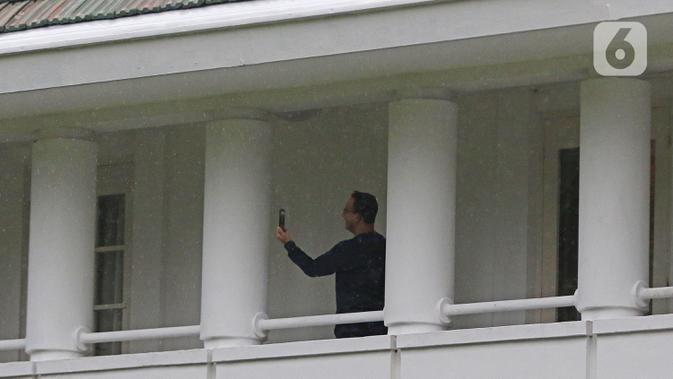 Gubernur DKI Jakarta Anies Baswedan melakukan video call dengan keluarga di rumah dinas Jalan Suropati, Menteng, Jakarta Pusat, Kamis (3/12/2020). Anies Baswedan melakukan isolasi mandiri di rumah dinas gubernur karena positif Covid-19 selama 14 hari ke depan. (Liputan6.com/Herman Zakharia)