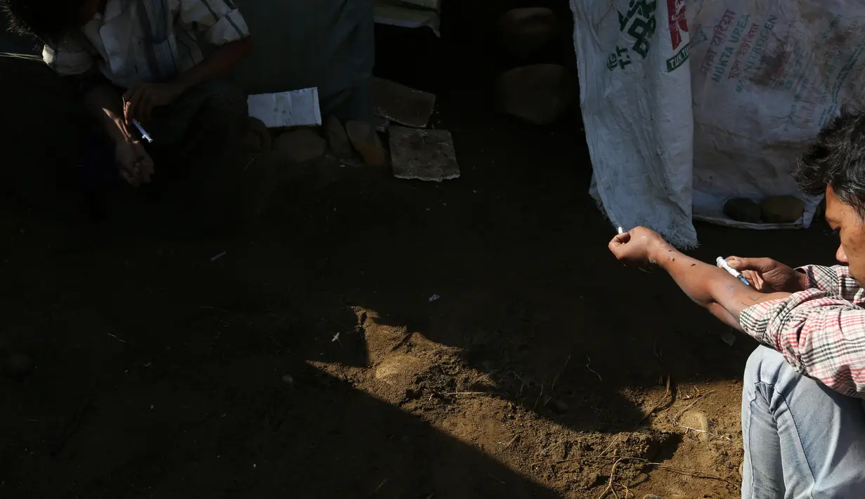 Dua penambang menyuntikan heroin di Tambang batu giok di Hpakant, Myanmar, 29 November 2015. Kecanduan narkotika sudah merabak pada penambang batu giok untuk digunakan dengan alasan agar kuat mencari & menemukan gumpalan batu mulia. (REUTERS/Soe Zeya Tun)
