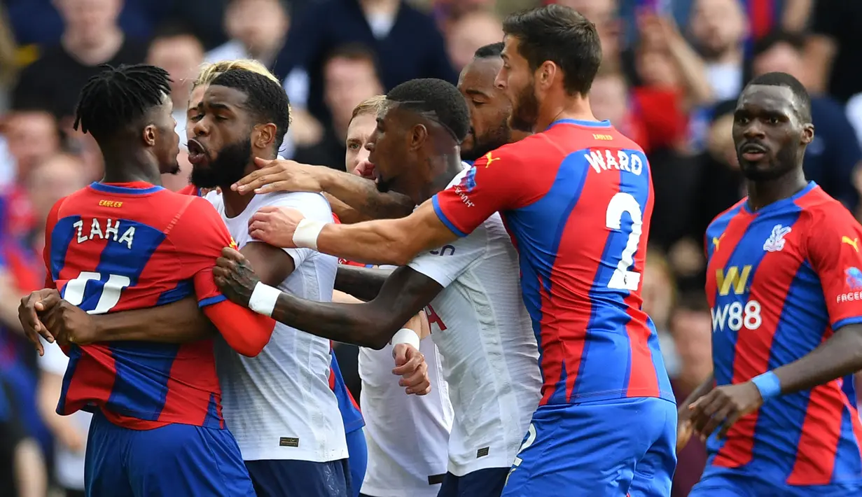 Japhet Tanganga (kiri kedua) menjadi salah satu faktor kekalahan perdana Tottenham Hotspur kala melawan Crystal Palace. The Lilywhites harus bermain dengan 10 pemain setelah Tanganga diganjar dua kartu kuning setelah ribut dengan Wilfred Zaha dan melanggar Jordan Ayew. (Foto: AFP/Justin Tallis)