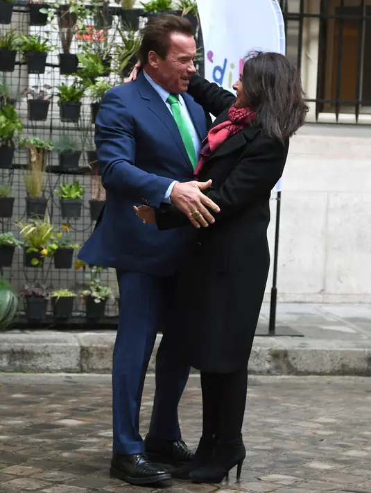 Gubernur California ke-38, Arnold Schwarzenegger memeluk Walikota Paris, Anne HIdalgo di Paris (11/12). Pertemuan puncak iklim One Planet dihadiri 50 pemimpin dunia dan di-host oleh U.N. dan Bank Dunia. (AFP Photo / Alain Jocard)