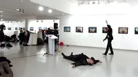 Dubes Rusia untuk Turki, Andrei Karlov tergeletak di lantai usai ditembak oleh seorang pria (kanan) di galeri seni di Ankara, Senin (19/12). Dubes Rusia ditembak dari belakang saat membuka pameran fotografi. (Depo Photos/Sozcu Newspaper via REUTERS)