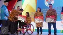 Menpora Imam Nahrawi (kedua kiri) menyerahkan bonus kepada Ni Nengah W peraih perunggu Paralimpiade Brasil 2016, Jakarta, Rabu (2/11). Usai menyerahkan bonus, Menpora juga meninjau pembangunan gedung olimpic centre. (Liputan6.com/Helmi Fithriansyah)
