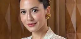 Pevita Pearce tampil memesona mengenakan atasan kebaya brokat putih lengan panjang sebagai inner dipadukan buister warna biru yang dihiasi bros besar serasi dengan anting-anting dan hiasan rambutnya. [ @pevpearce]