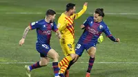 Lionel Messi dikepung pemain Huesca. Barcelona menang tipis 1-0, Senin (04/01/2021) dini hari WIB. (Pau BARRENA / AFP)