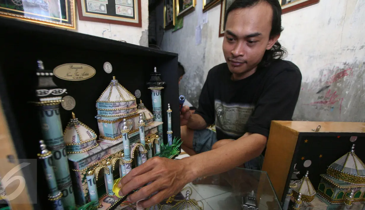 Seorang perajin, Albani, menyelesaikan mahar pernikahan berbentuk miniatur masjid, di dusun Jotowang, Yogyakarta, Rabu (15/6). Pada Ramadan, pemesanan miniatur masjid berbahan dasar uang pecahan rupiah itu mengalami peningkatan (Liputan6.com/Boy Harjanto)