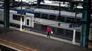 Pekerja kereta berjalan di peron saat mogok massal karyawan terjadi di Stasiun Lyon Perrache, Prancis, Selasa (3/4). Layanan kereta internasional antara Paris dan Milan diganti dengan layanan bus. (AP Photo/Laurent Cipriani)