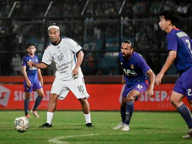 Ronaldinho kembali turun ke lapangan hijau. Mantan bintang Barcelona itu turut ambil bagian dalam acara trofeo Meet the Star di Stadion Kanjuruhan, Kabupaten Malang, Minggu (26/6/2022). (Bola.com/Iwan Setiawan)
