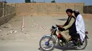 Warga berkendara melewati ladang ranjau di desa Nad-e-Ali, provinsi Helmand pada 9 November 2021. Sekitar 41.000 warga sipil Afghanistan terbunuh atau terluka oleh ranjau darat dan persenjataan yang tidak meledak sejak 1988, menurut Layanan Pekerjaan Ranjau PBB (UNMAS). (Javed TANVEER/AFP)