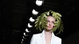 Seorang model mengenakan koleksi Womenswear Spring/Summer 2018 untuk desainer Jepang Junko Shimada di Paris Fashion Week, Selasa (3/10). Junko menampilkan para model dengan rambut unik yang dihiasi daun. (AP Photo/Christophe Ena)