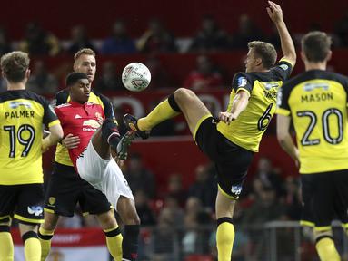 Aksi pemain Manchester United, Marcus Rashford (tengah) mengontrol bola dari adangan para pemain Burton Albion pada laga Piala Liga Inggris di Old Trafford, Manchester (20/9/2017). MU menang 4-1. (Martin Rickett/PA via AP)