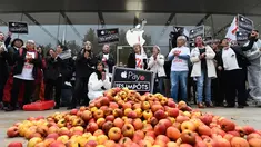 Aktivis ATTAC berada di dekat apel dan tulisan "bayar pajak anda" berunjuk rasa di luar toko Apple saat peluncuran iPhone X di Aix-en- Provence, Prancis (3/11). Unjuk rasa ini menentang penghindaran pajak oleh Apple. (AFP Photo/Anne-Christine Poujoulat)