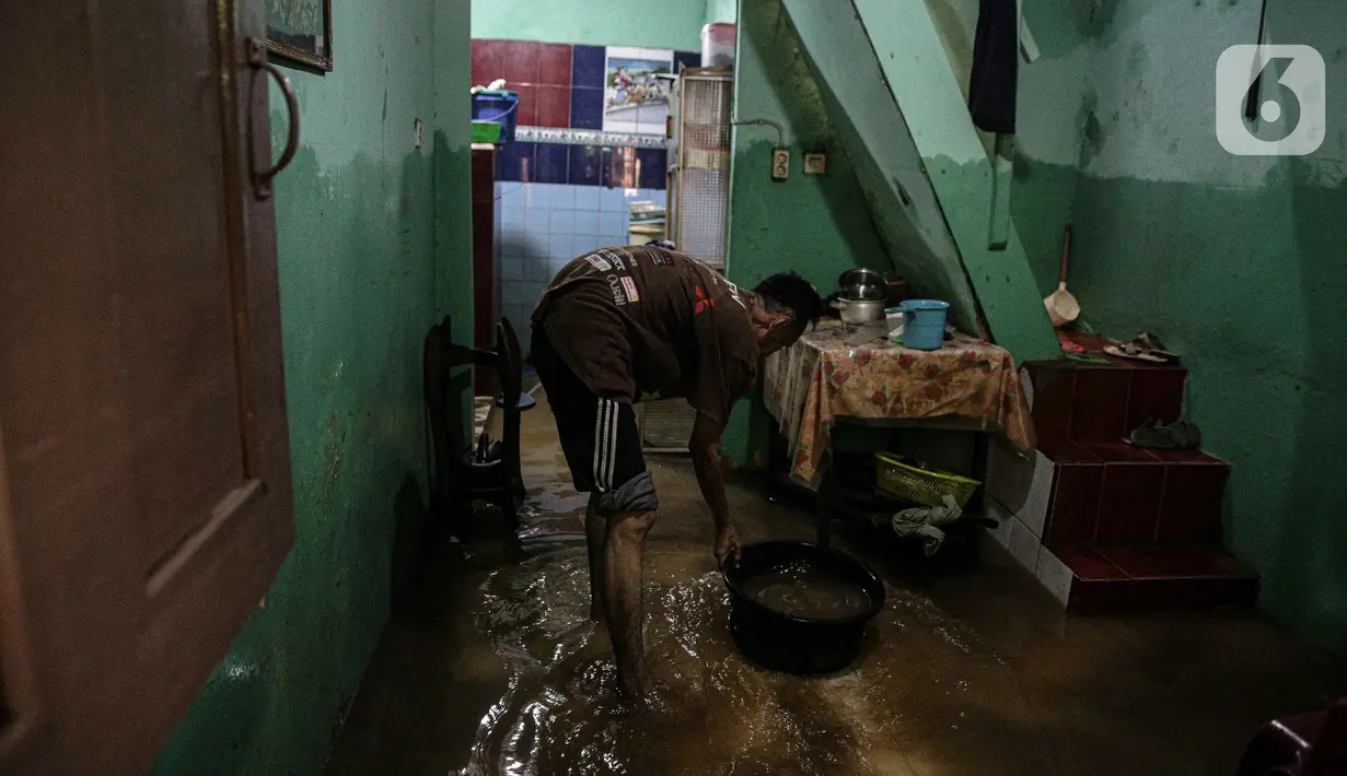 Warga bersih-bersih rumah usai terendam banjir di kawasan Kampung Melayu, Jakarta, Senin (8/11/2021). Banjir akibat luapan Kali Ciliwung tersebut merendam pemukiman setinggi 60 cm sejak 7 November 2021 sore. (Liputan6.com/Faizal Fanani)