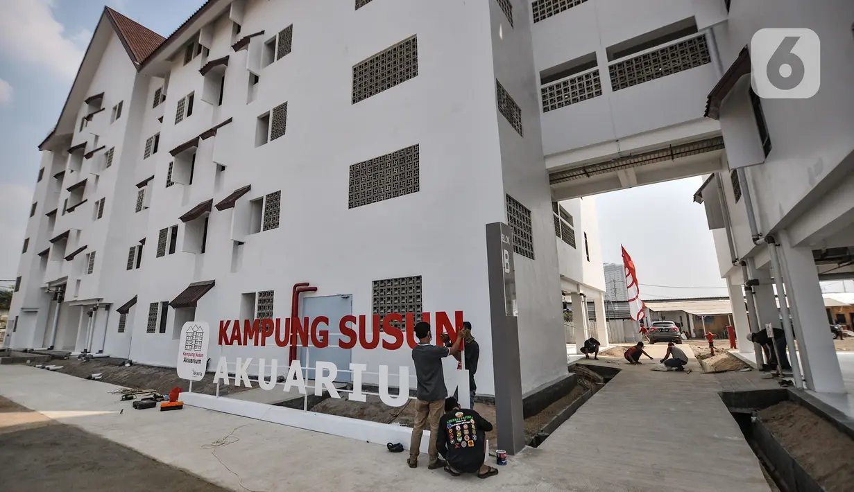 Pekerja saat memasang papan nama Kampung Susun Akuarium, Jakarta, Selasa (17/8/2021). Para warga Kampung Akuarium nantinya akan secara bertahap menghuni unit mulai bulan ini. (merdeka.com/Iqbal S. Nugroho)
