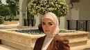 Tampil elegan dengan padu padan loose dress, puffed blazer, dan hijab segi empat yang dililit ke belakang. [@nuin.azahari]