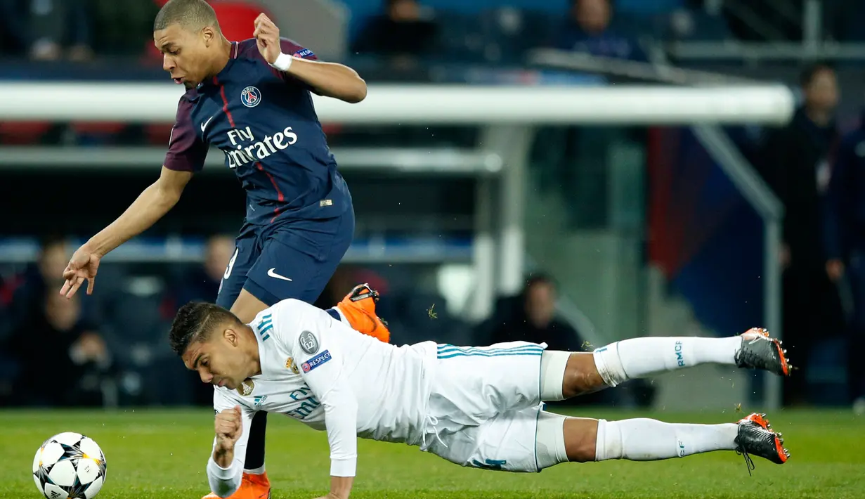 Pemain Real Madrid Casemiro mencoba menghentikan aksi pemain Paris Saint-Germain Kylian Mbappe saat pertandingan Liga Champions leg kedua di stadion Parc des Princes di Paris (6/3). (AP / Francois Mori)