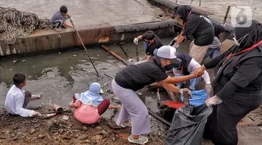 Anak-anak pesisir membersihkan sampah di kawasan Cilincing, Jakarta Utara, Minggu (5/12/2021). Fenomena rob yang diprediksi BMKG berlangsung dari 2-9 Desember 2021 di Jakarta menginisiasi anak-anak Kelas Jurnalis Cilik untuk bersih-bersih kawasan pesisir. (merdeka.com/Iqbal S. Nugroho)