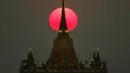 Matahari terbenam di belakang Kuil Wat Saket, atau Gunung Emas di Bangkok, Thailand (11/3). (Reuters/Athit Perawongmetha)