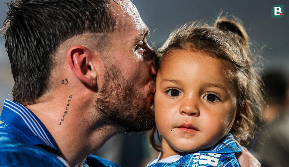 Gelandang Persib Bandung, Marc Klok mencium sang putri, Sage Luan Klok dalam perayaan gelar juara Championship Series BRI Liga 1 2023/2024 setelah mengalahkan Madura United 3-1 pada laga final leg kedua di Stadion Gelora Bangkalan, Madura, Jumat (31/5/2024). (Bola.com/Bagaskara Lazuardi)