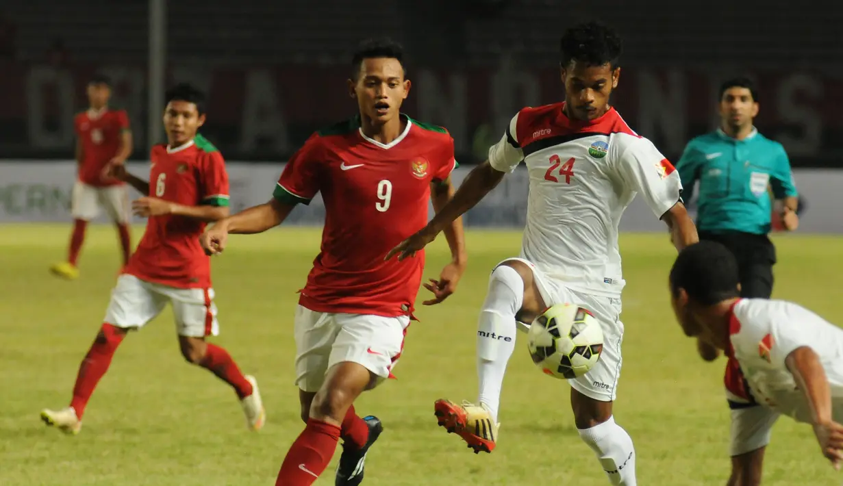 Penyerang timnas Indonesia U-23, Muchlis Hadi Ning Syaifulloh (tengah) berebut bola dengan Ezequiel Dos Santos Fernandes (Timor Leste) di kualifikasi grup H Piala Asia 2016 di Stadion GBK Jakarta, Jumat (27/3/2015). (Liputan6.com/Helmi Fithriansyah)
